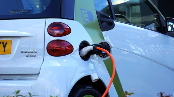 An electric Smart car plugged into a charging station