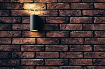 A wall sconce against a brick wall